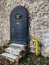 Black iron door to castle with ornaments and window behind bars, Pezinok, Slovakia