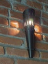 Black iron electric torch light on the red brick wall background Royalty Free Stock Photo