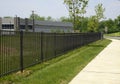 Black iron fence by a sidewalk