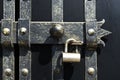 Black iron gate, brass squares and a lock with latch Royalty Free Stock Photo