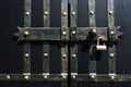 Black iron gate, brass squares and a lock with latch Royalty Free Stock Photo
