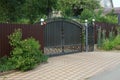 Black iron gate and brown metal fence on the sidewalk Royalty Free Stock Photo