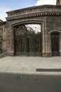 Black iron gates and doors covered with openwork and wrought iron fence pattern near a 19th century house in Gyumri Royalty Free Stock Photo