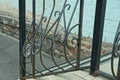 Black iron handrails with a wrought pattern over gray concrete steps on the street Royalty Free Stock Photo