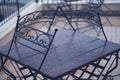 Black iron metal chairs near table on rainy outdoor terrace Royalty Free Stock Photo