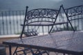 Black iron metal chairs near table on rainy outdoor terrace Royalty Free Stock Photo