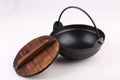 Black iron pot with wooden lid on white background Royalty Free Stock Photo