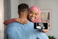 Black Islamic Lady Embracing Husband And Holding Smartphone With Baby Sonography Photo Royalty Free Stock Photo