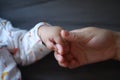 Black isolated background baby put little hand in his mother palm maternal love family concept hand-in-hand Royalty Free Stock Photo