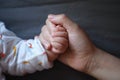 Black isolated background baby put little hand in his mother palm maternal love family concept hand-in-hand Royalty Free Stock Photo