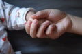 Black isolated background baby put little hand in his mother`s palm love family concept Royalty Free Stock Photo