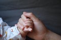 Black isolated background baby put little hand in his mother palm maternal love family concept hand-in-hand Royalty Free Stock Photo