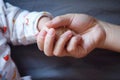 Black isolated background mother mom hold son hand finger new-born infant baby hand in hand maternal love family happiness concept Royalty Free Stock Photo