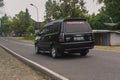 Black Isuzu panther family car driving fast on the road in the afternoon
