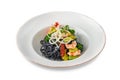 Black Italian seafood pasta with shrimps, cherry tomatoes and greens. Pasta with cuttlefish ink, cooked sea food macaroni Royalty Free Stock Photo