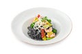 Black Italian seafood pasta with shrimps, cherry tomatoes and greens. Pasta with cuttlefish ink, cooked sea food macaroni Royalty Free Stock Photo