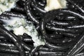 Black Italian spaghetti  pasta with blue cheese with mold and olive oil. Royalty Free Stock Photo