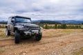 Black jeep parked by the road with picturesque mountain, forests and clouds panorama on the background Royalty Free Stock Photo