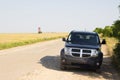 Black jeep stand on broken road in open field