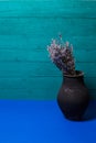 black jug with lavender flowers on a blue background Royalty Free Stock Photo