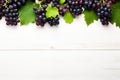 Black juicy grapes on white background. Autumn frame made of grapes