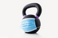 Black kettle bell with purple markings with blue surgical mask Royalty Free Stock Photo