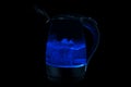 Black kettle with boiling water on a black background Royalty Free Stock Photo