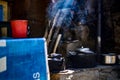 Black kettles kept on a mud shelf in a village with smoke Royalty Free Stock Photo