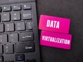 Black keyboard and colored board with the word Data Virtualization - Business concept