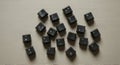 Black keyboard keys scattered on a textured beige surface. The keys include letters, Royalty Free Stock Photo