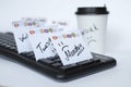 On the black keyboard many stickers with the names of the days of the week. next to a paper Cup of coffee with the inscription