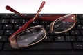 Productivity Essentials: Red Glasses and Black Keyboard on Office Desk