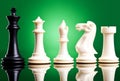 Black king near white chess pieces Royalty Free Stock Photo