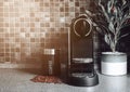 Black kitchen with home coffee machine and beans and morning sunlight Royalty Free Stock Photo
