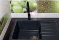 Black kitchen sink and faucet, tiles on the wall. Repair in the house installation of plumbing Royalty Free Stock Photo