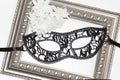 Black lace eye mask, vintage frame and white flowers Royalty Free Stock Photo