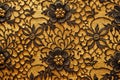 Black lace floral design on gold fabric texture Royalty Free Stock Photo