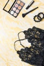 Black lace lingerie with beauty care products, make up cosmetics, jewelry in black and gold. Fashion flat lay, top view Royalty Free Stock Photo