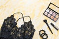 Black lace lingerie with beauty care products, make up cosmetics, jewelry in black and gold. Fashion flat lay, top view Royalty Free Stock Photo