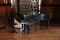 Black lacquered grand piano in the old hall