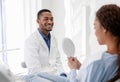 Black lady checking beautiful smile in mirror, dentist watching her Royalty Free Stock Photo