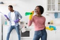 Black lady having fun with her boyfriend while cleaning kitchen Royalty Free Stock Photo