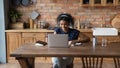 Black lady in headphones watch webinar on laptop taking notes Royalty Free Stock Photo