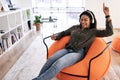Black lady listening to music in wireless headphones and dancing Royalty Free Stock Photo