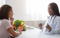 Black lady nutritionist showing female patient medical chart