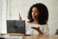 Black lady wearing a headset begins a lesson online, looks at a laptop screen, Royalty Free Stock Photo