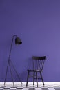 Black lamp and chair set on a violet wall in simple living room Royalty Free Stock Photo