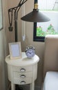 Black lamp, picture frame and alarm clock on table