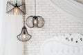 Black lamps in light bedroom interior. Three modern black lamps hanging