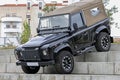 Black Land Rover Defender off-road jeep on concrete stairways during an exhibition in a park